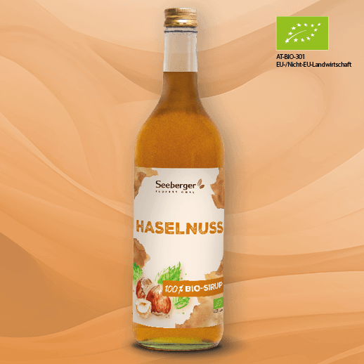 Glasflasche mit Seeberger-Bio-Sirup in der Geschmacksrichtung Haselnuss und EU-Bio-Logo