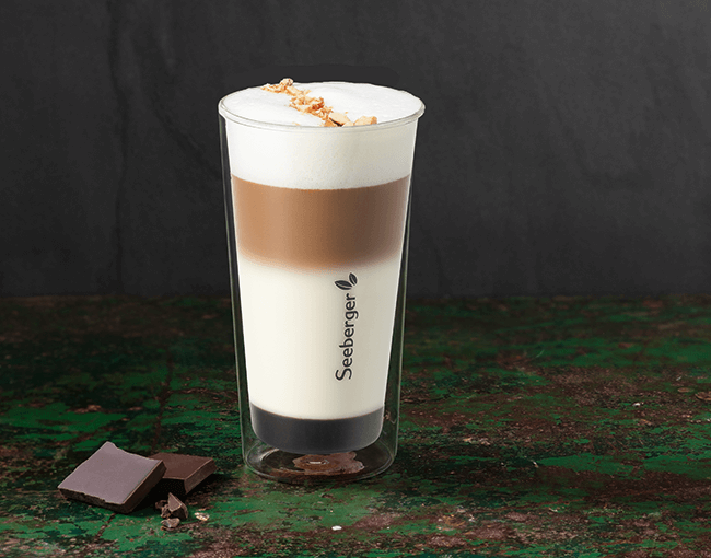 Nougat Latte im Glas mit Schokolade daneben